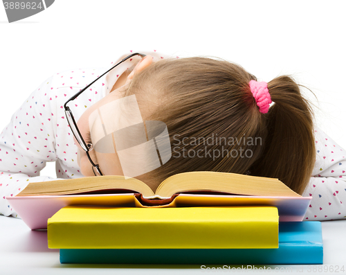 Image of Little girl is sleeping on her books