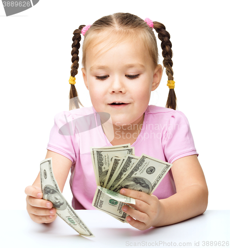 Image of Little girl is counting dollars