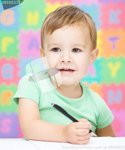 Image of Little boy is writing on his copybook