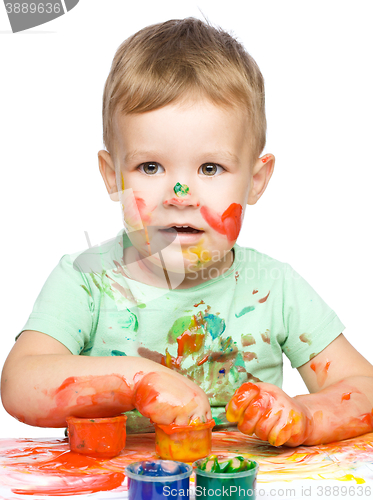 Image of Little boy is playing with paints