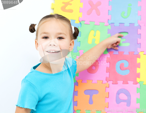 Image of Little girl is pointing at letter Z on alphabet