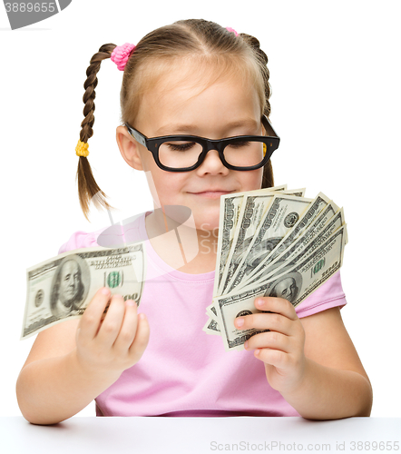 Image of Little girl is counting dollars