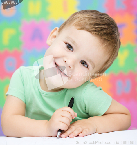 Image of Little boy is writing on his copybook