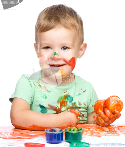 Image of Little boy is playing with paints