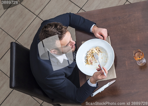 Image of Man Eating Penne Pasta