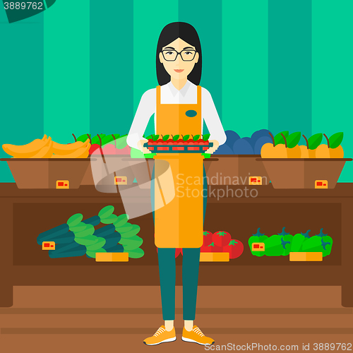 Image of Supermarket worker with box full of apples.