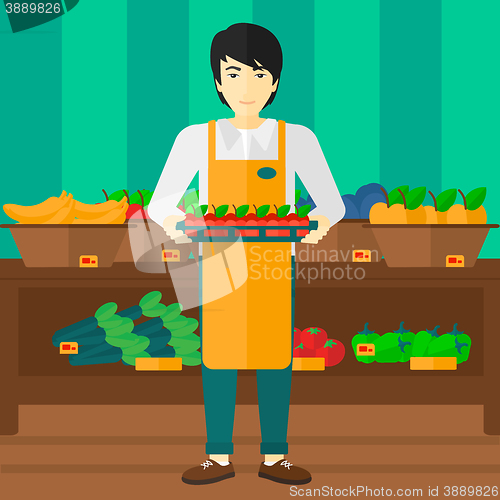 Image of Supermarket worker with box full of apples.