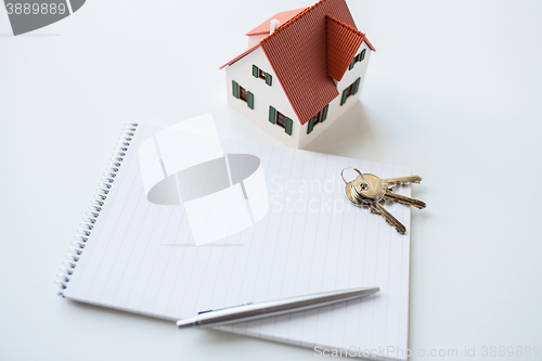 Image of close up of home model, house keys and notebook