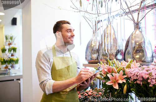 Image of florist man with clipboard at flower shop