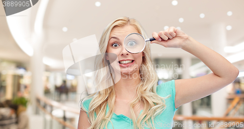 Image of happy young woman with magnifying glass