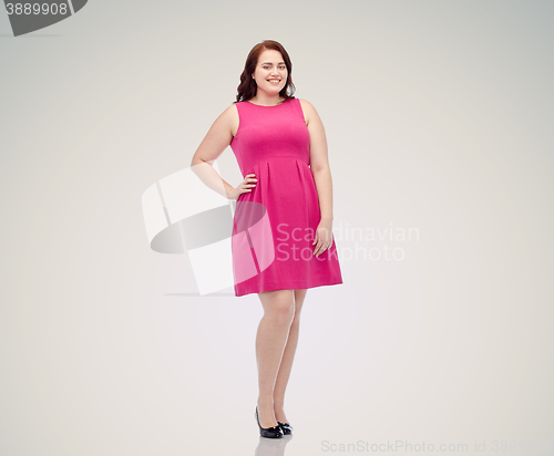 Image of happy young plus size woman posing in pink dress