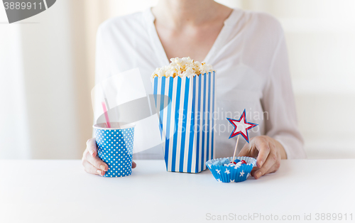 Image of woman eating popcorn with drink and candies