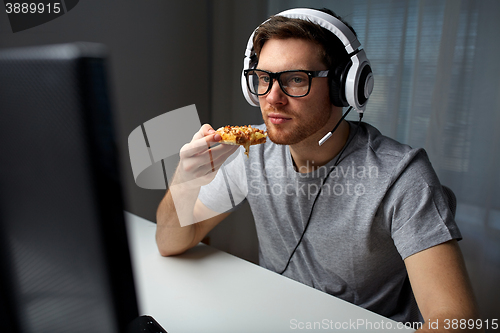 Image of man in headset playing computer video game at home