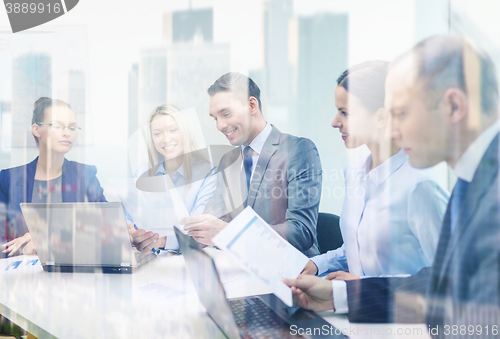 Image of business team with laptop having discussion