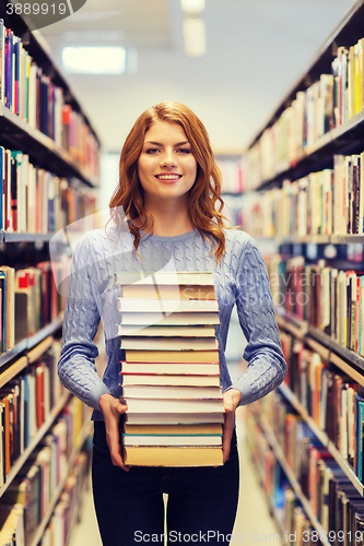 Image of happy student girl or woman with books in library