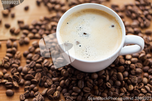 Image of close up coffee cup and grains on wooden table