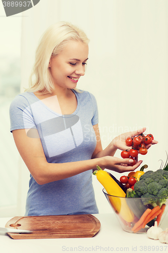 Image of smiling young woman cooking vegetables at home