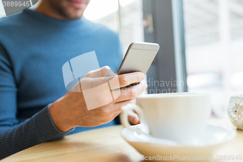 Image of close up of man with smartphones at cafe