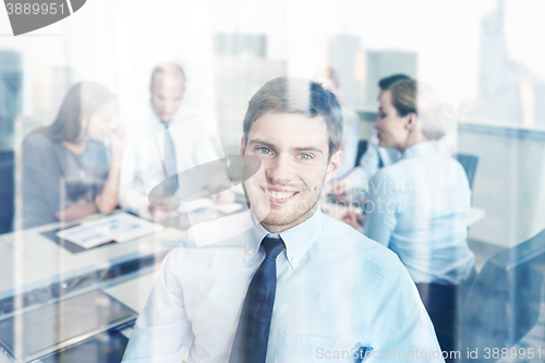 Image of group of smiling businesspeople meeting in office