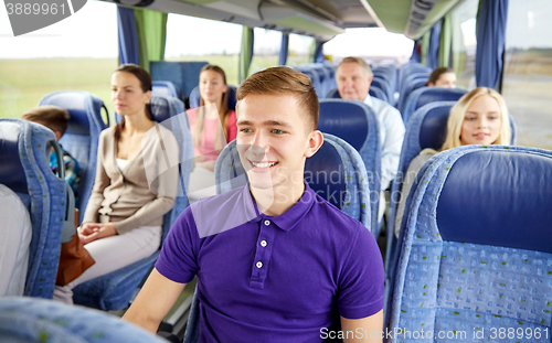 Image of happy young man sitting in travel bus or train