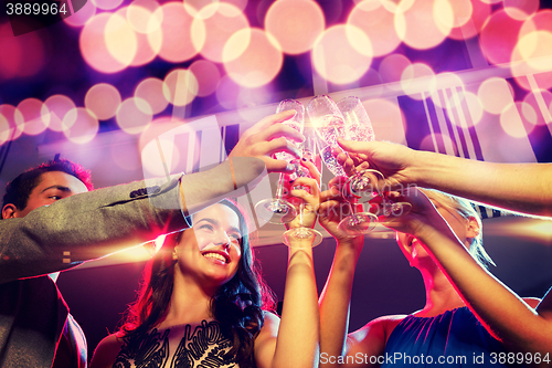 Image of smiling friends with glasses of champagne in club