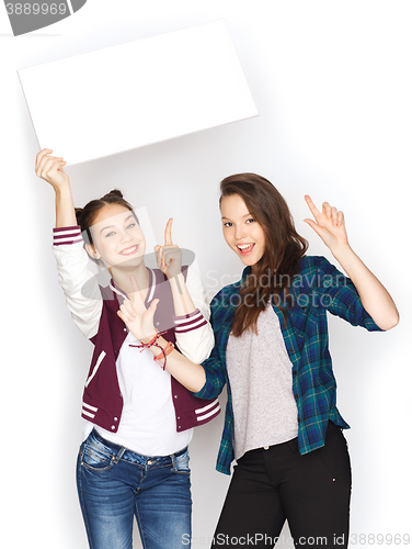 Image of smiling teenage girls holding white blank board