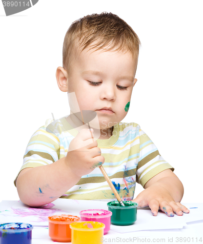 Image of Little boy is playing with paints