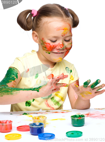 Image of Portrait of a cute girl playing with paints