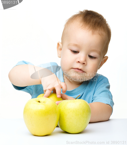 Image of Portrait of a cute little boy with yellow apples