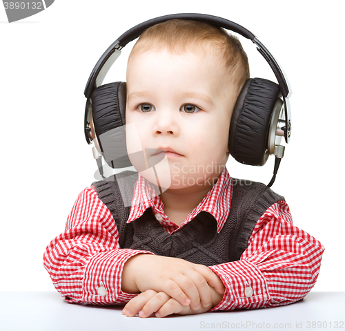 Image of Cute little boy enjoying music using headphones