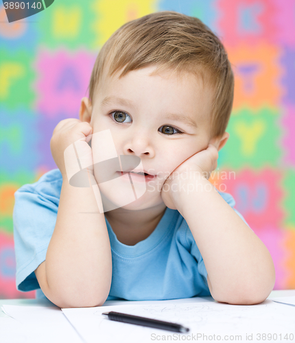 Image of Little boy is writing on his copybook