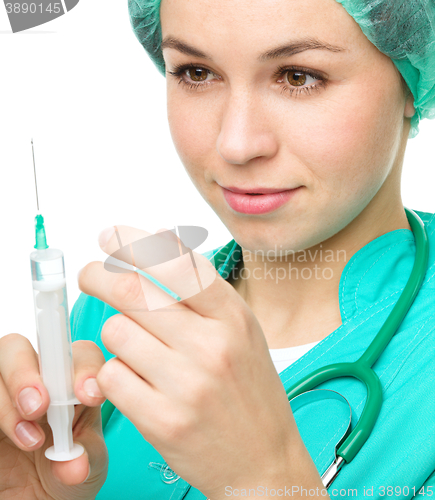 Image of Young nurse is preparing syringe for injection