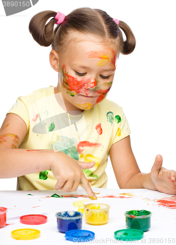 Image of Portrait of a cute girl playing with paints