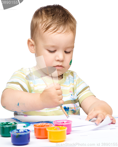 Image of Little boy is playing with paints