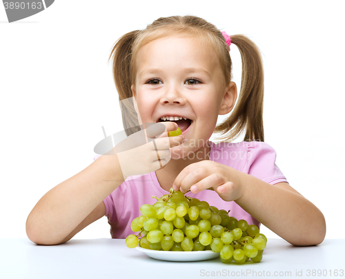 Image of Little girl is eating grapes