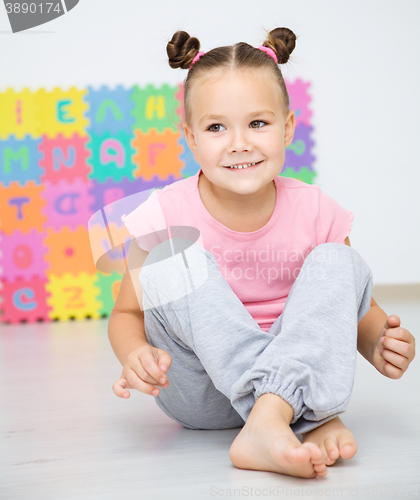 Image of Little girl is sitting on floor in preschool