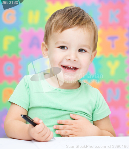 Image of Little boy is writing on his copybook