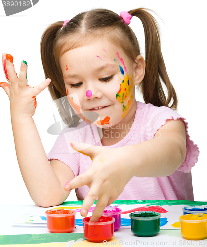 Image of Portrait of a cute girl playing with paints