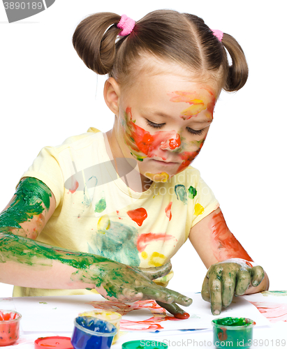 Image of Portrait of a cute girl playing with paints