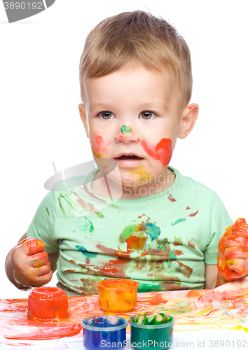 Image of Little boy is playing with paints