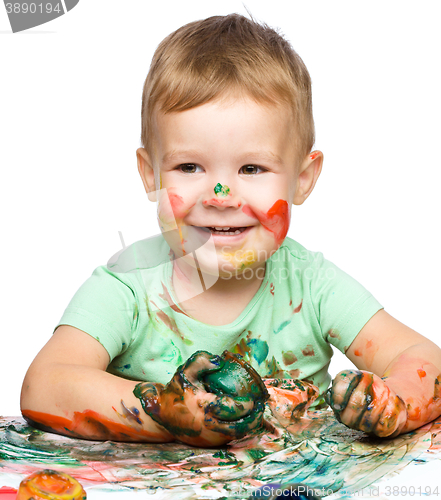 Image of Little boy is playing with paints