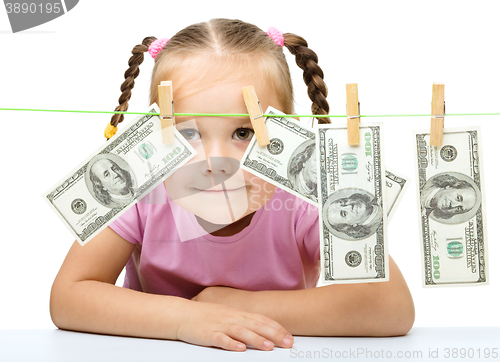 Image of Cute little girl is playing with paper money