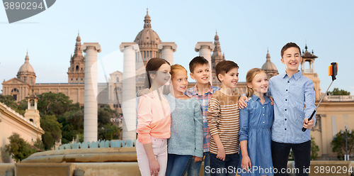 Image of happy children with smartphone and selfie stick