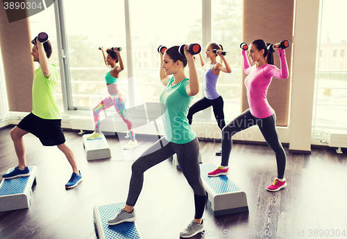 Image of group of people with dumbbells and steppers