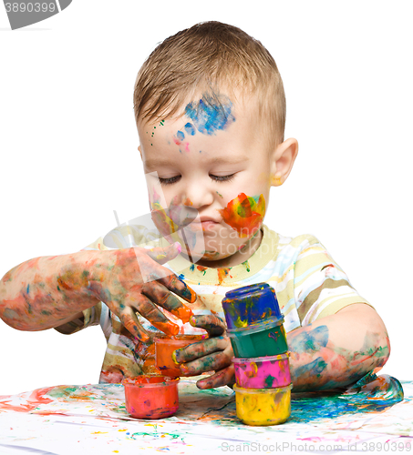 Image of Portrait of a cute little boy playing with paints