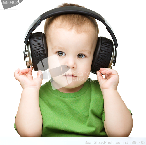 Image of Cute little boy enjoying music using headphones