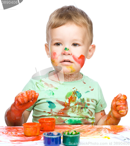 Image of Little boy is playing with paints