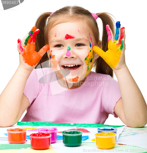 Image of Portrait of a cute girl playing with paints