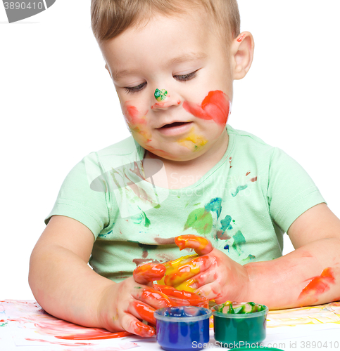 Image of Little boy is playing with paints