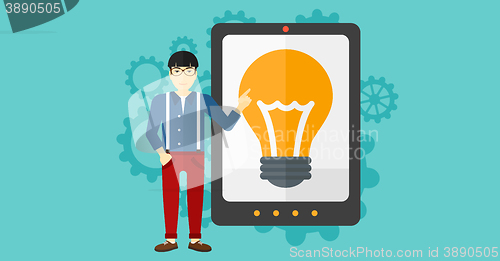 Image of Man pointing at tablet computer with light bulb on screen.